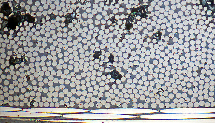 Sections through carbon fibres (7 µm diameter) in laminate (metallurgical microscope, vertical reflected light)